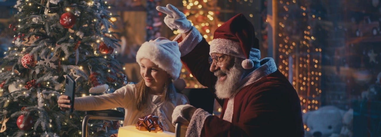 Girl in a wheelchair taking a selfie with Santa