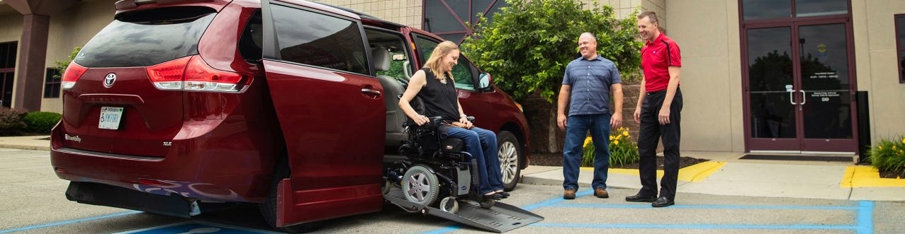 Woman in a Electric Wheelchair using a Ramp to get out of her Wheelchair Accessible Vehicle