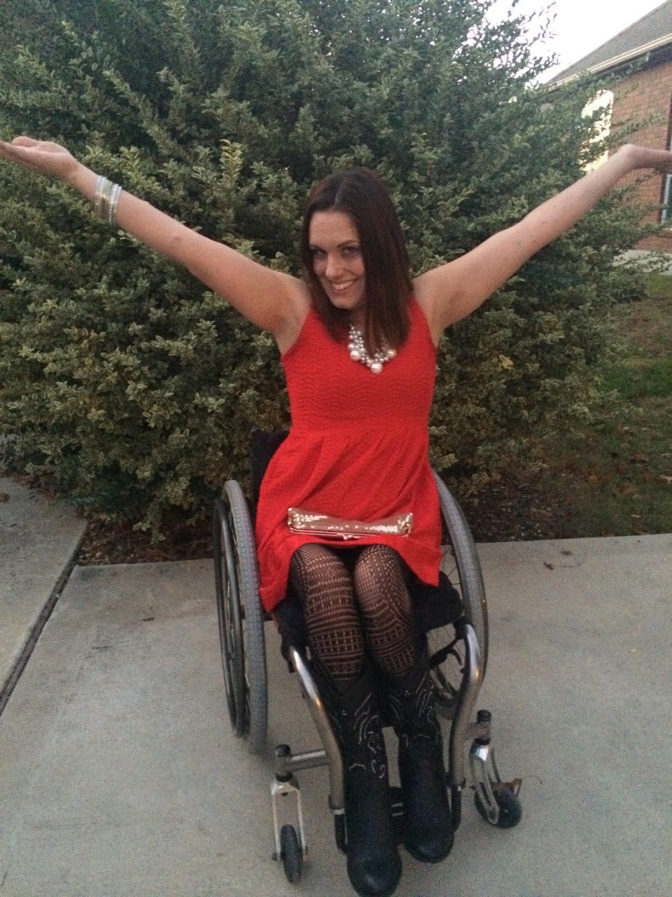 Priscilla Hedlin is modeling her pretty red dress that she paired with a gold necklace, black tights and black boots