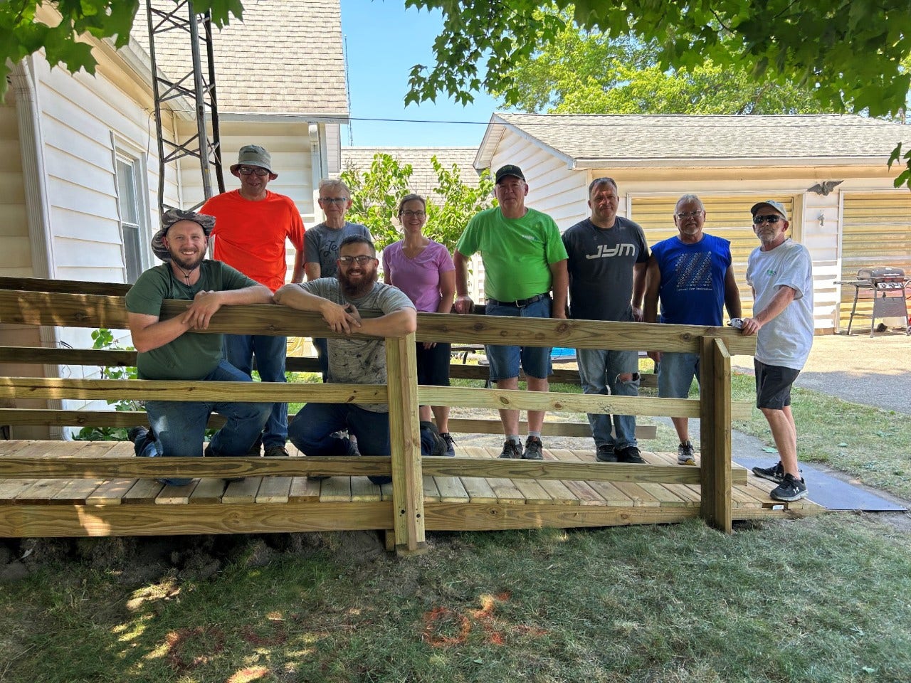 A group of people gather on a wheelchair ramp