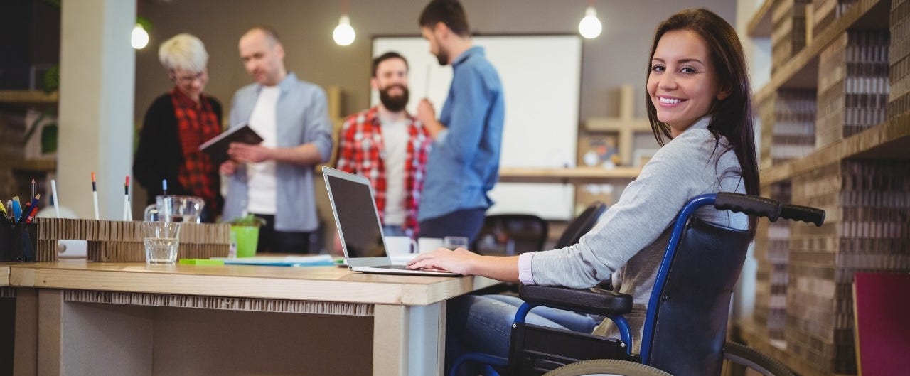 Confident disabled businesswoman using laptop in office What to know before you buy an accessible van